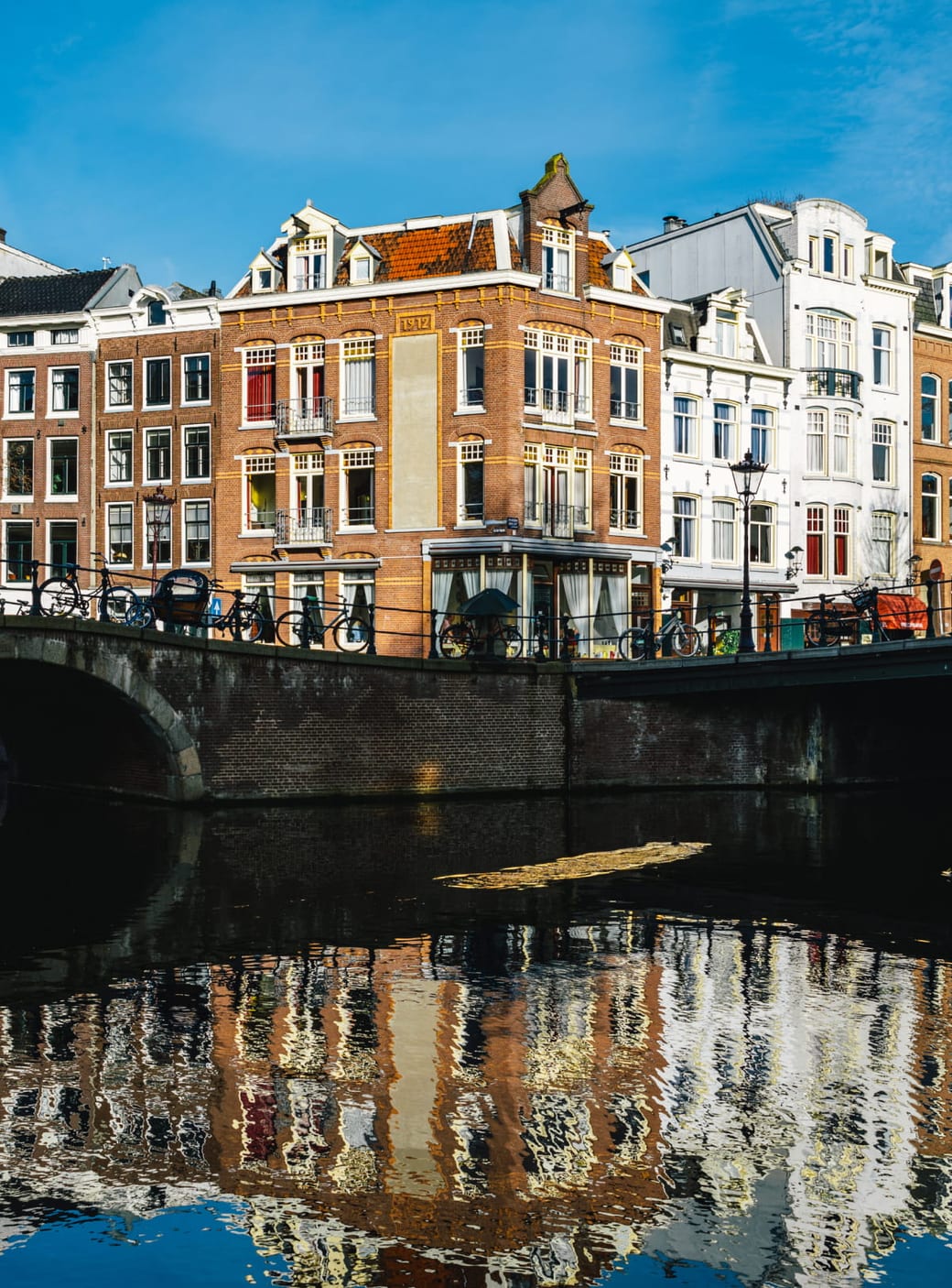 Amsterdam canal houses and a bridge reflected in the canal