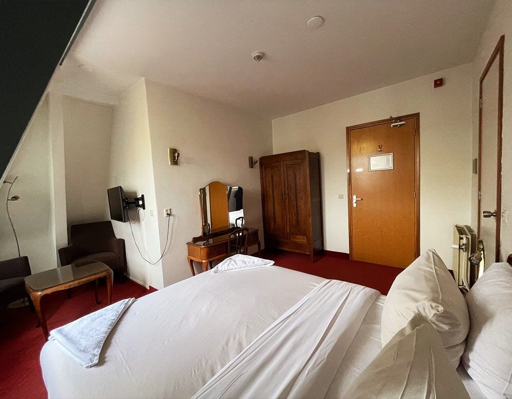 Double Loft Room with Canal View: double bed beneath the sloping ceiling, with a dressing table and wardrobe