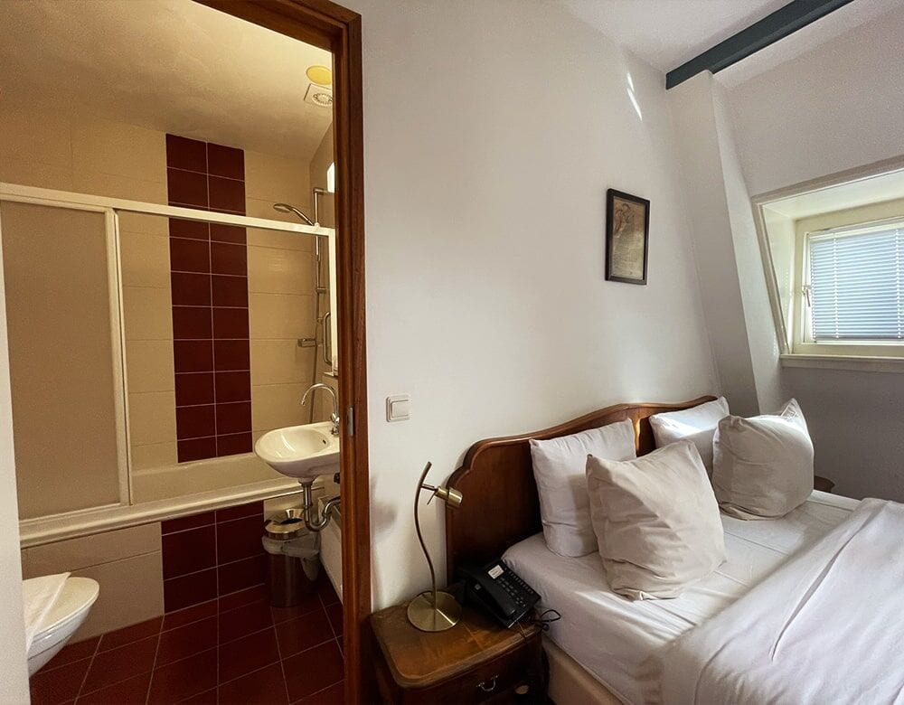 Double Loft Room with Canal View: the bedside, looking towards the bathroom and the dormer window