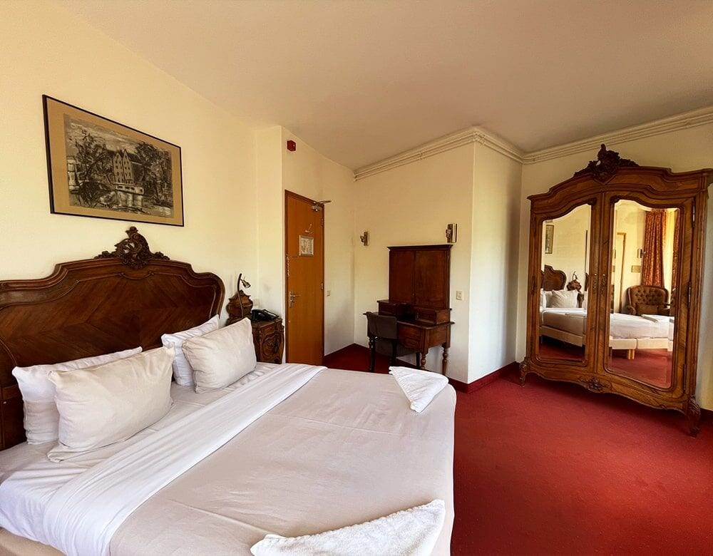 Double Room with Canal View: carved headboard and an antique mirrored wardrobe