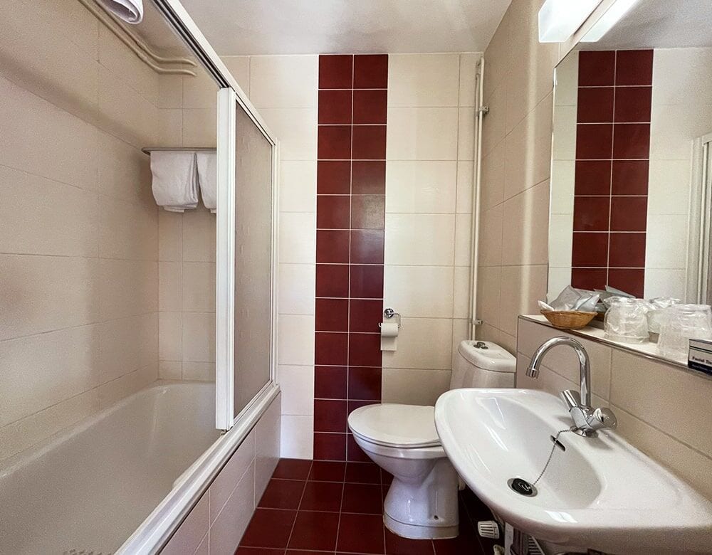 Double Room with Canal View: private bathroom with a bathtub, washbasin and red-tiled accents