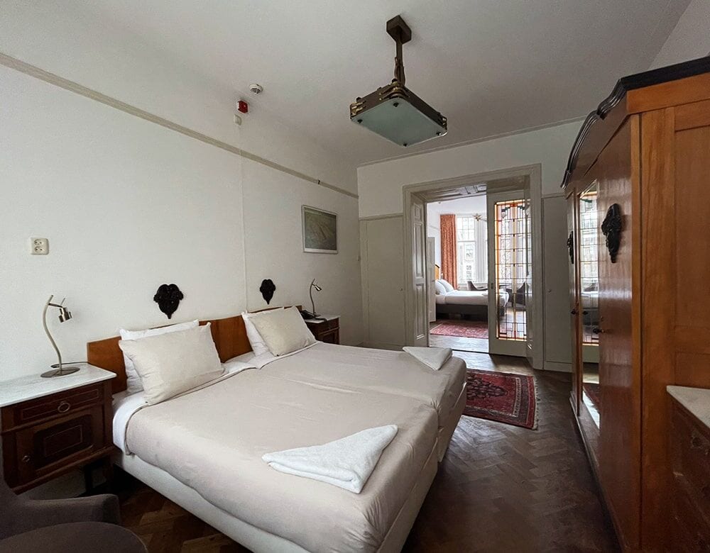 Family Suite: beds pushed together, with a doorway through to the second room