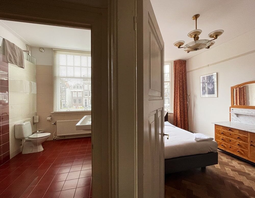 Family Suite: looking from the bathroom into the bedroom, with a parquet floor and chandelier