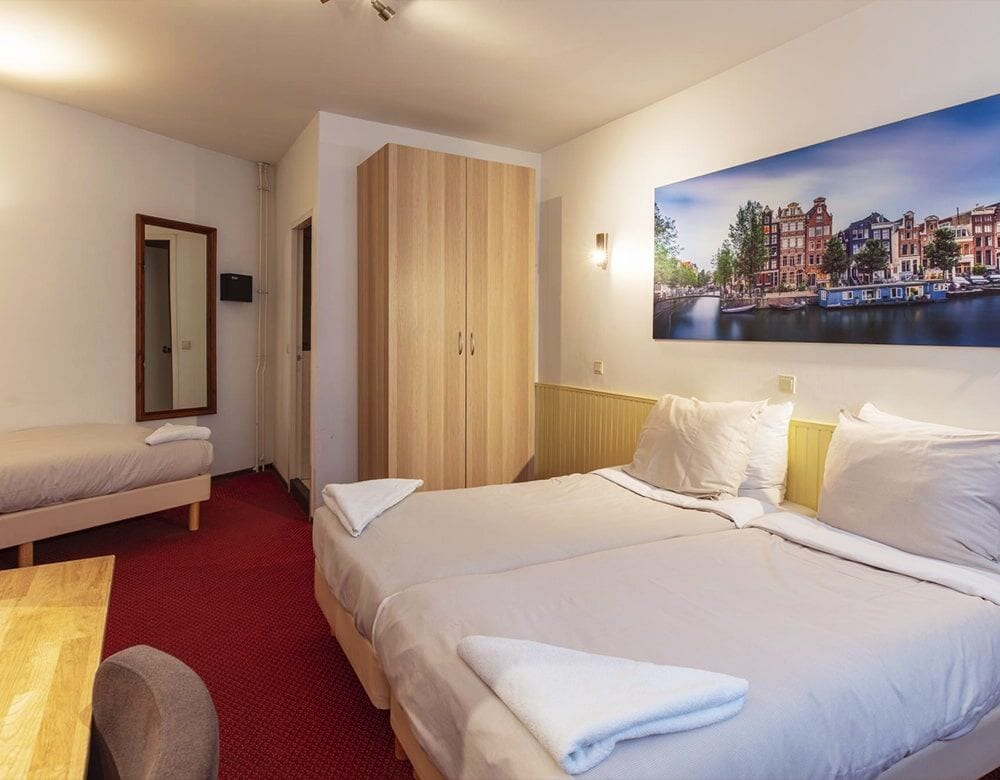 Triple Room: single beds beneath a panoramic photograph of Amsterdam's canals