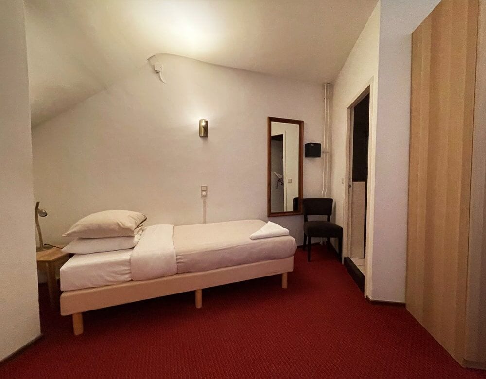 Triple Room: a single bed beside a wardrobe and mirror