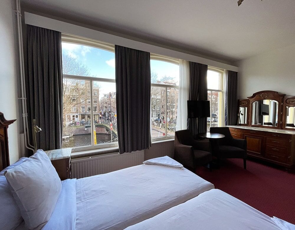 Twin Room with Canal View: two single beds before a wide window onto the Prinsengracht