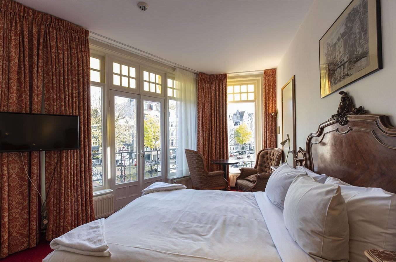Corner room with french windows onto the canal, two armchairs and a table between them