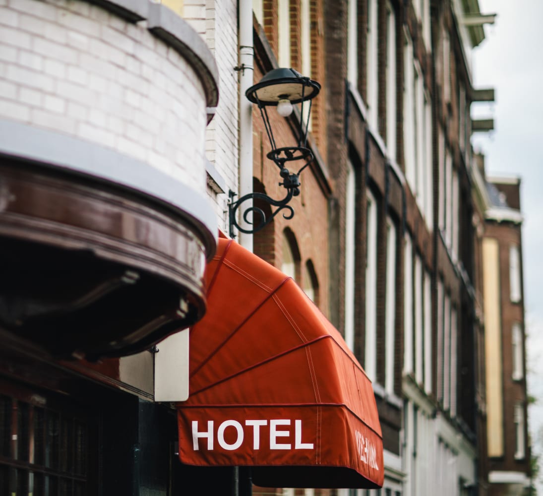 The red HOTEL awning on the corner of the Wiechmann Hotel, beneath a wrought-iron lantern